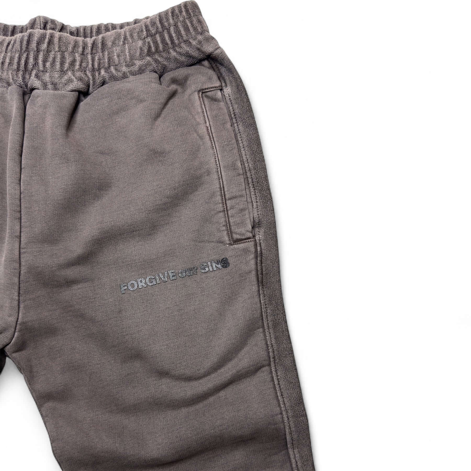 Vintage brown sweatpants with 'FORGIVE our SINS' logo and side pocket, featuring drawcords on both legs.